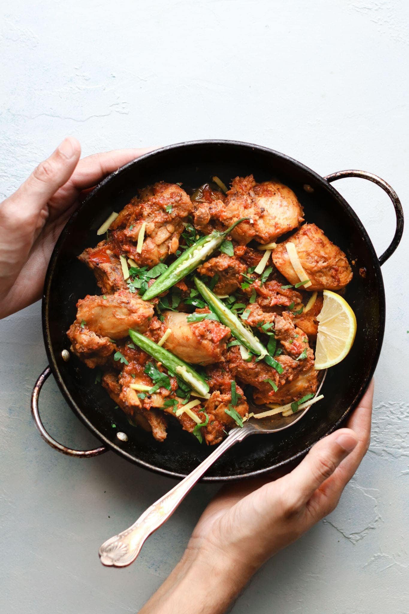 Spicy Thai Chicken Karahi with fresh basil in a black wok